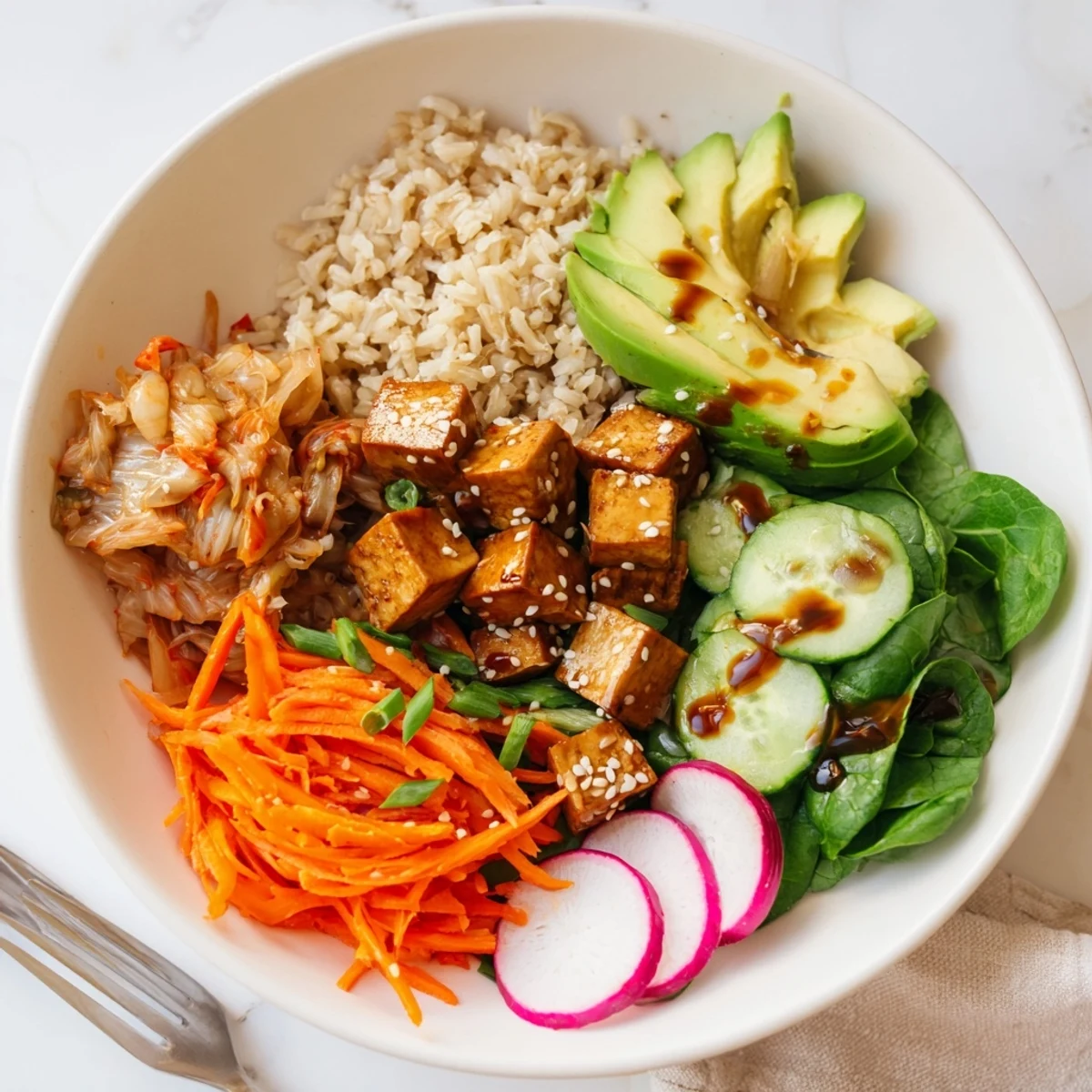 Vibrant bowl featuring crispy radishes, kimchi, and a zesty sesame dressing.