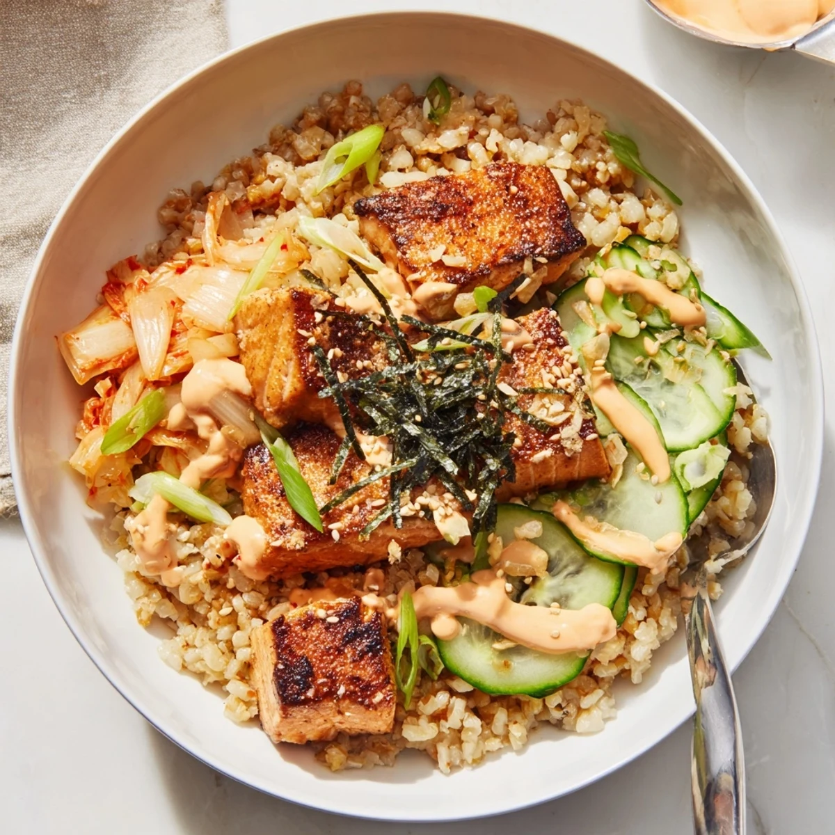 A delightful Crispy Salmon Rice Bowl garnished with fresh avocado and crunchy garlic.