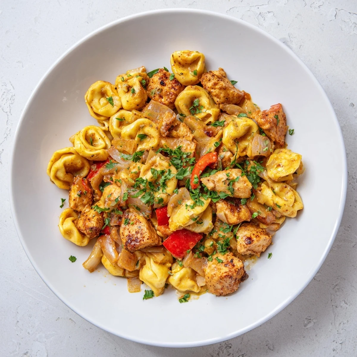 Golden Zesty Cajun Garlic Parmesan Chicken Tortellini, a creamy, spicy pasta dish ready to serve.