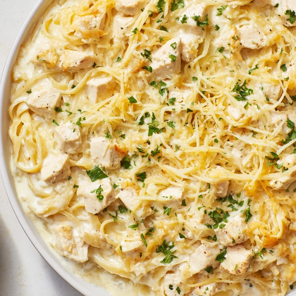 Golden-baked Chicken Fettuccine Alfredo, a bubbly casserole topped with melted mozzarella cheese.