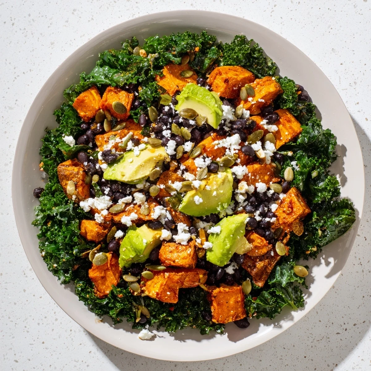 Enjoy a refreshing massaged kale salad combining sweet potato, crunchy pepitas, and a vibrant, flavorful dressing.