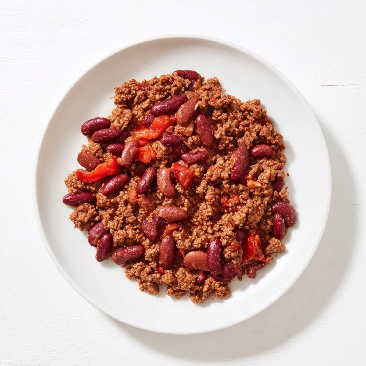 Steaming bowl of The Secret 4-Ingredient Slow Cooker Chili Dump, ready to be topped with shredded cheese.