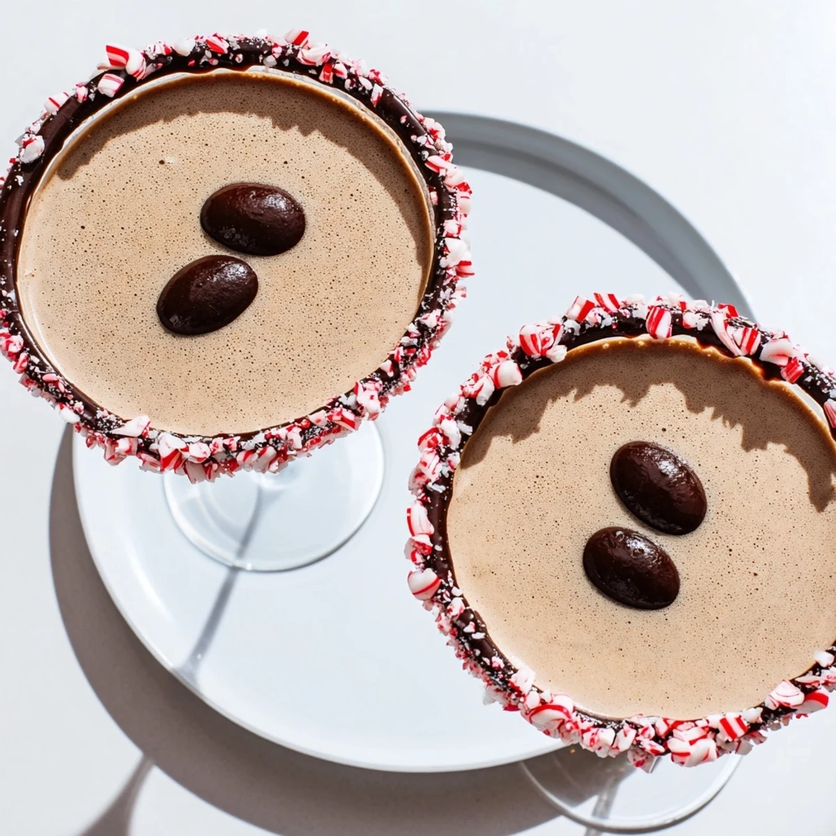 Frothy Peppermint Espresso Martinis, boasting a chocolate and crushed candy cane rim, ready to serve.