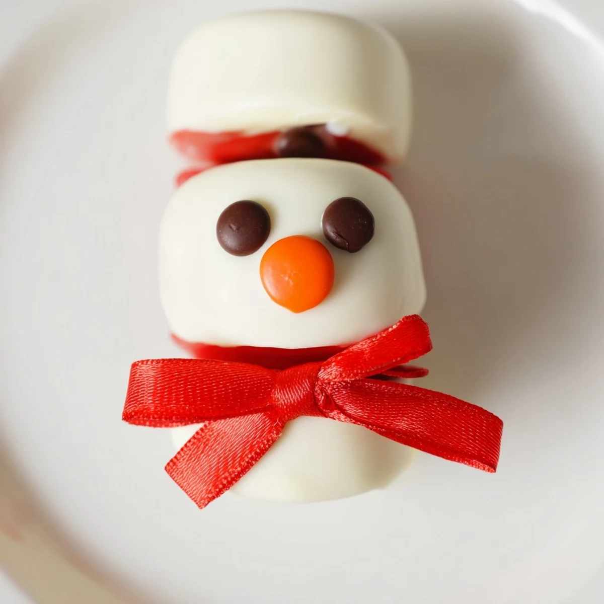 Express Snowman Marshmallow Pops, dipped in white chocolate, ready for a winter treat alongside hot cocoa.