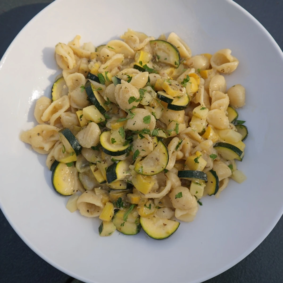 Steam rising from the warm, creamy One-Pot Zucchini Ditalini, garnished with fresh parsley.