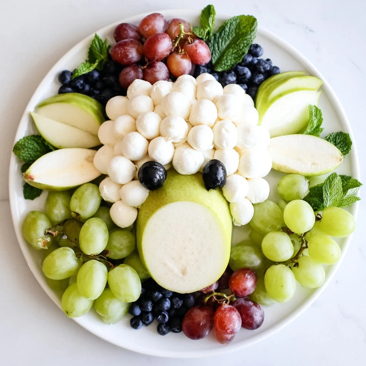 Lamb face fruit and cheese platter with fresh green apple "ears" and creamy mozzarella.