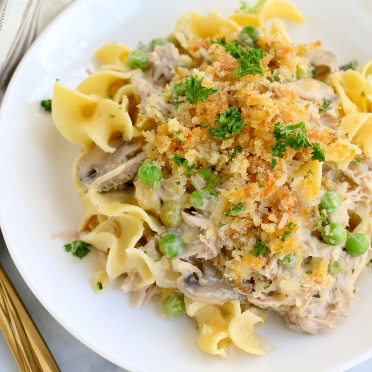 Hearty tuna noodle casserole, fresh from the oven, ready to serve with parsley garnish and flavor.