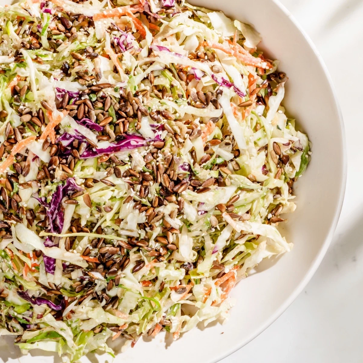 Enjoy a refreshing scoop of Crunchy Coleslaw Salad, featuring shredded cabbage and carrots with toasted seeds.