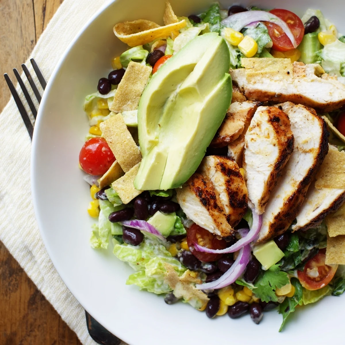 A vibrant serving of Honey Lime Chicken Taco Salad, garnished with fresh cilantro and drizzled with a tangy honey-lime dressing.