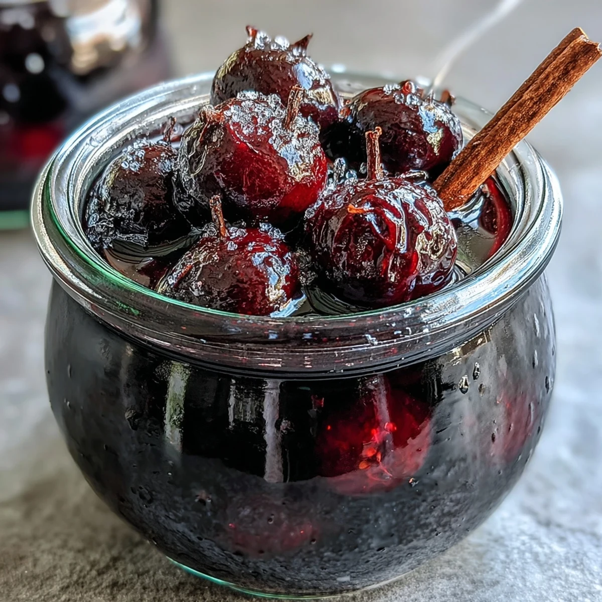 Deep ruby Black Currant Rum Liqueur poured into a glass, garnished with fresh berries.