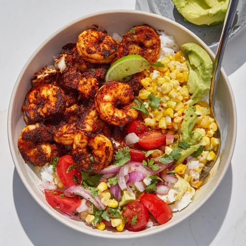 Delicious blackened shrimp bowl served with fresh avocado corn salsa and lime wedges.  