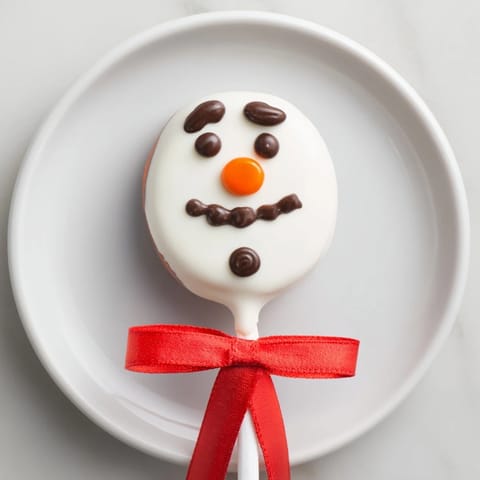 Festive Express Snowman Marshmallow Pops, complete with orange noses and candy scarves, perfect for holiday gifts.
