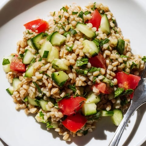 A close-up of fresh Middle Eastern Bulgur Wheat Salad Tabbouleh with herbs, juicy tomatoes, and olive oil-lemon vinaigrette, ready to serve as a light vegan side.  