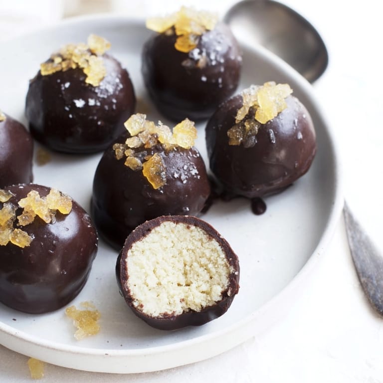 Elevated view of creamy Cinnamon Ginger Ricotta Truffles dusted with cinnamon on parchment paper.