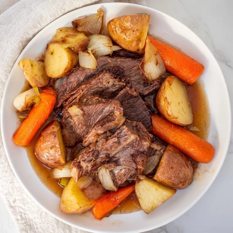 Fork-tender Sunday Pot Roast, surrounded by roasted carrots and potatoes, ready to be devoured.